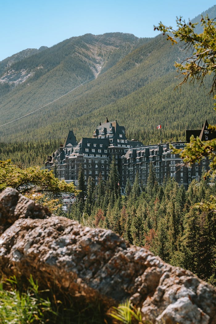 Explore the iconic Fairmont Banff Springs Hotel nestled in the scenic mountain landscape of Banff, Canada.